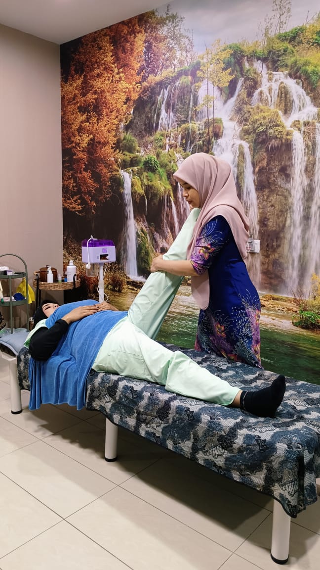 Pengamal Rumah Sihat Pendang melakukan teknik urutan kelegaan kepada pelanggan